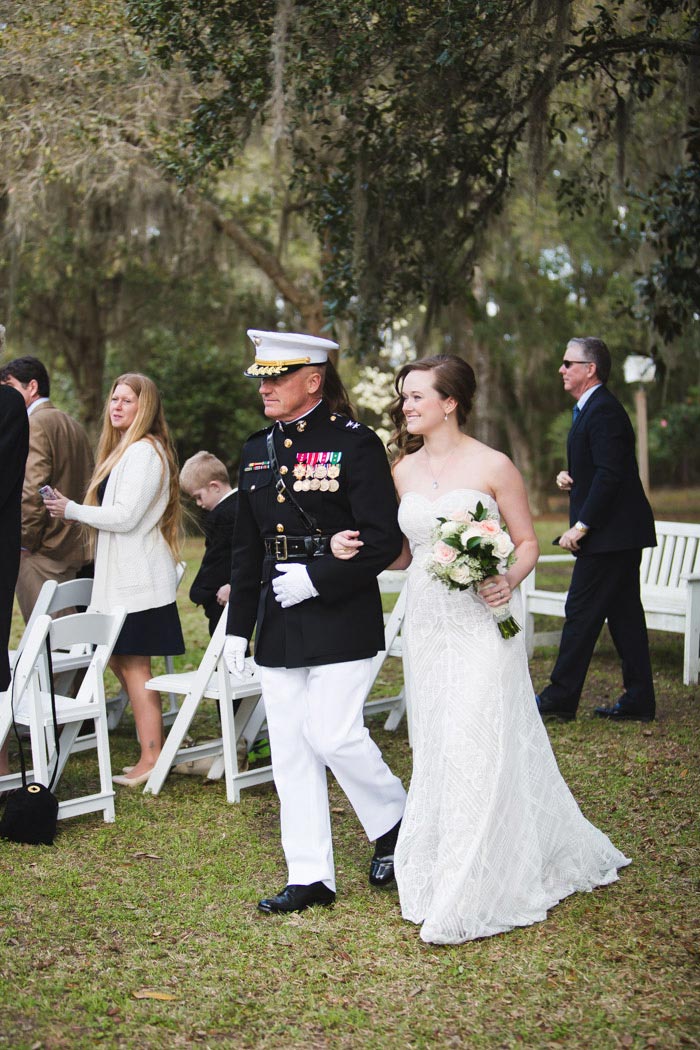 bride walking down the aisle with father in naval uniform