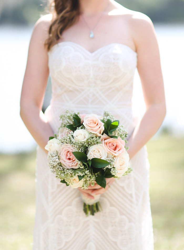 bride holding pink and white rose wedding bouquet