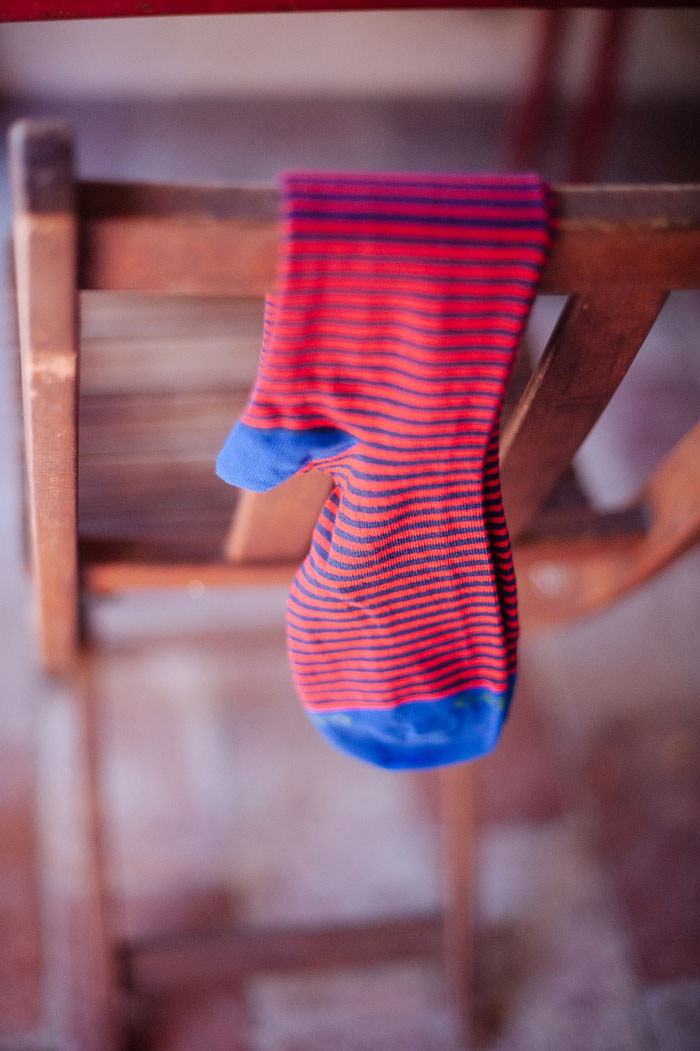 groom's red and blue striped socks hanging over chair