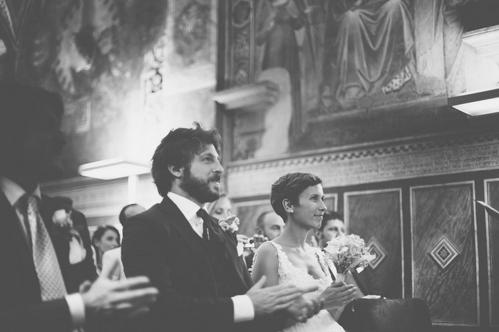 bride and groom sitting in Tuscan Church 