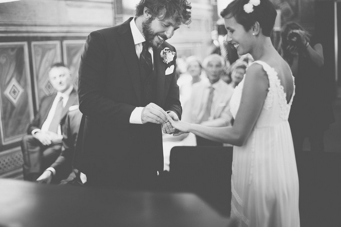 groom putting ring on bride's finger