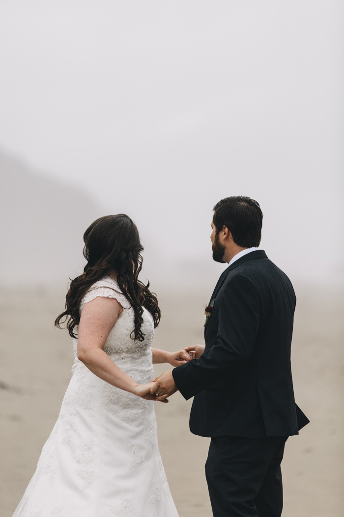 bride and groom holding hands on the beach