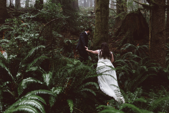 bride and groom hiking through oregon forest