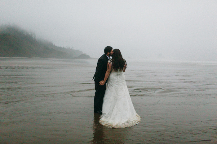 bride and groom kissing on foggy Oregon beach