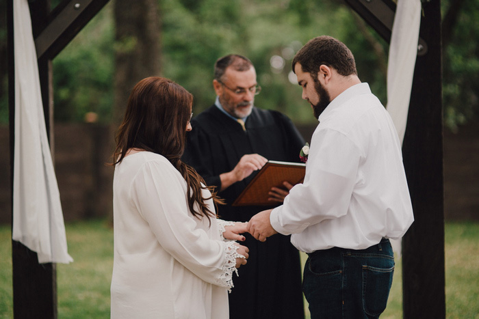 groom putting ring on bride's finger