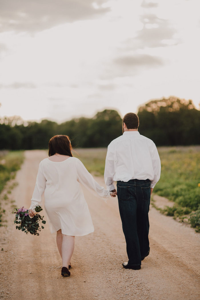 bride and groom walking down dirt road