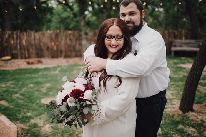 groom embracing bride from behind