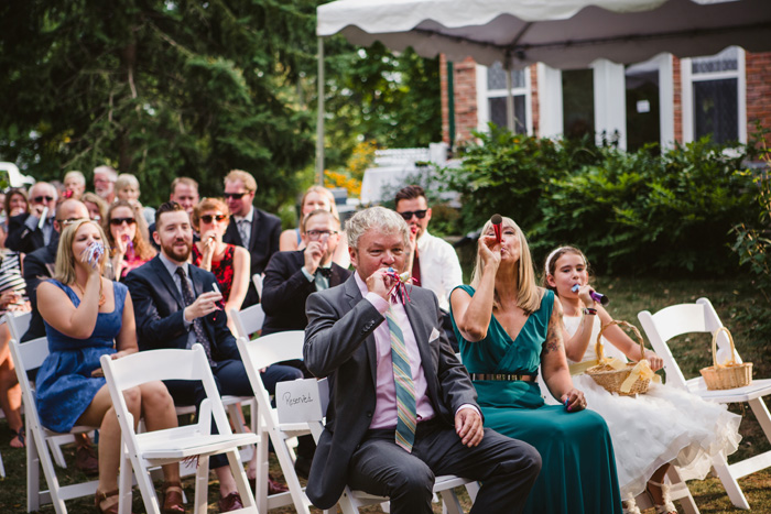 guests with party blowers at ceremony