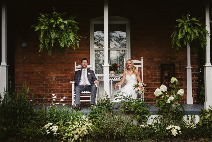 bride and groom sitting on inn porch