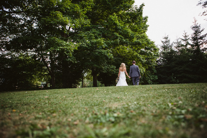 bride and groom walking across field