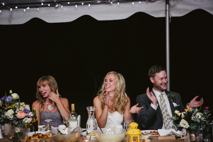 bride and groom listening to speeches at recpetion