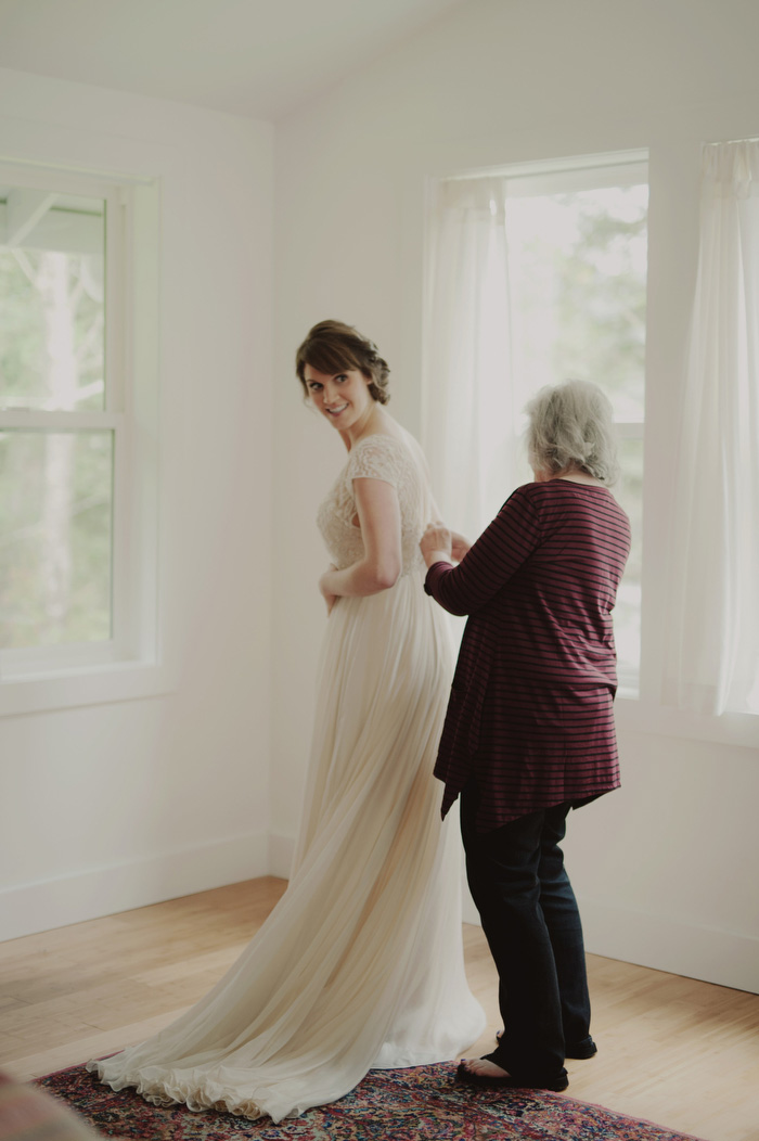 bride getting her dress buttoned up