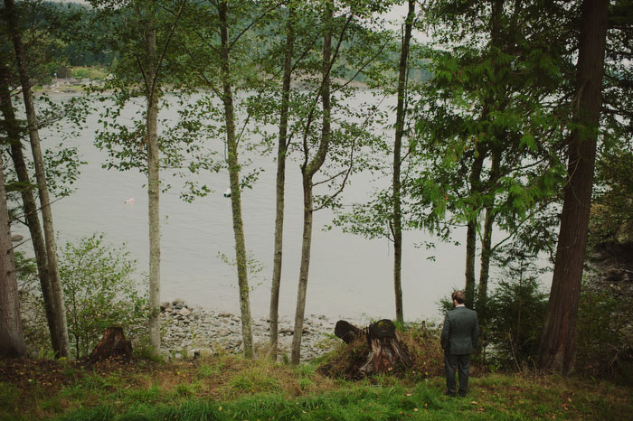 groom standing by the water