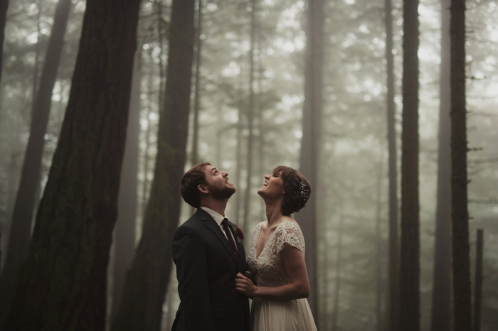 bride and groom looking up at the trees