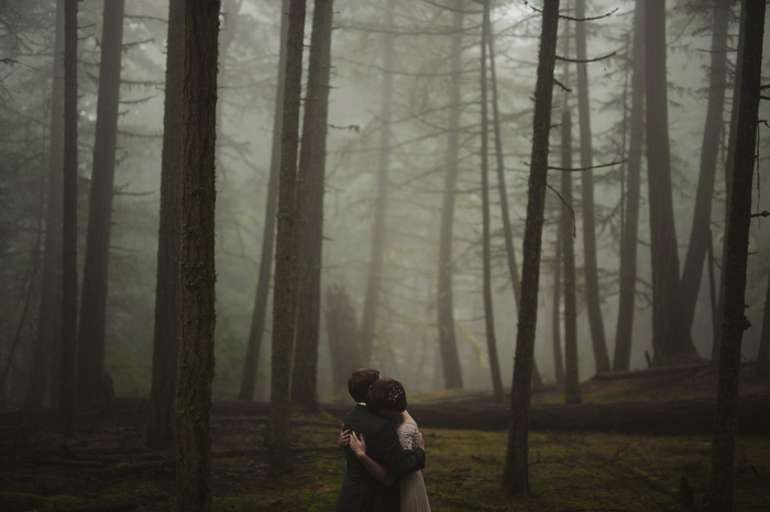 bride and groom hugging in foggy woods