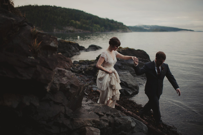 bride and groom walking on the rocks