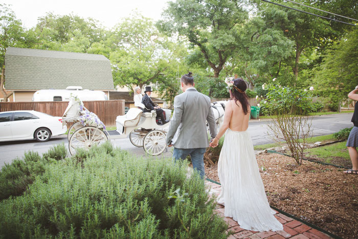 brie and groom walking toward horse drawn carriage