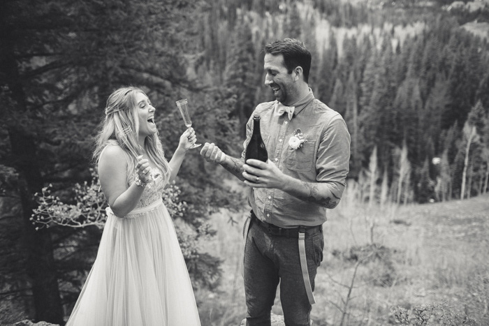 bride and groom celebrating on mountainside