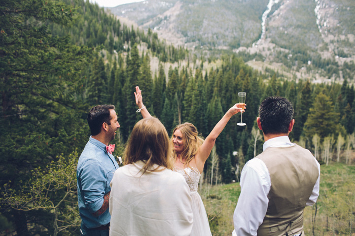 bride and groom celebrating on mountainside