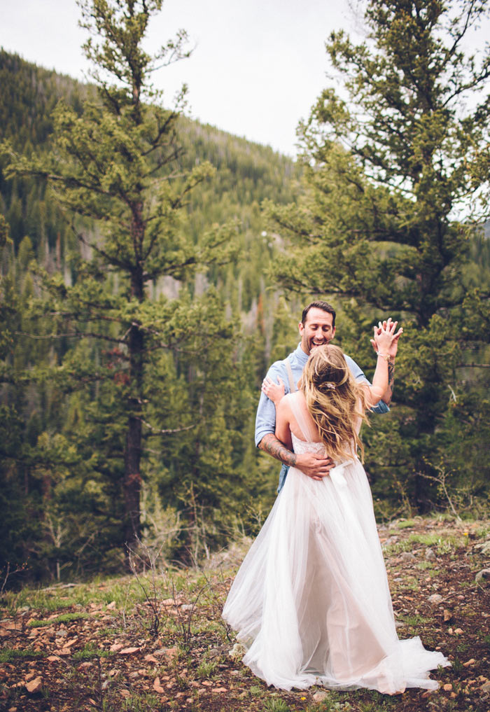 bride and groom dancing on mountainside