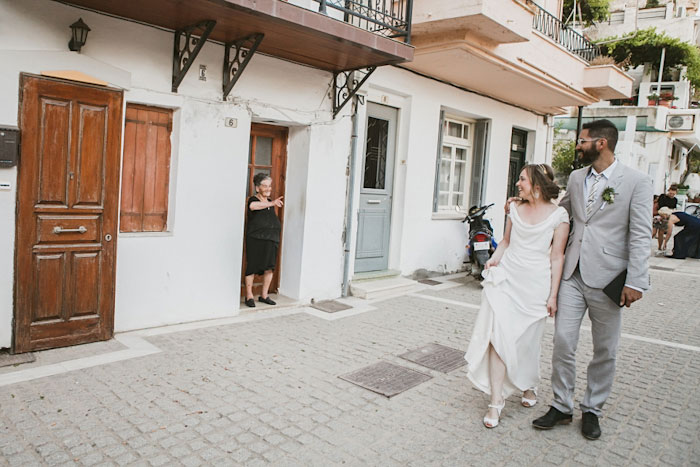 bride and groom walking down greek village street