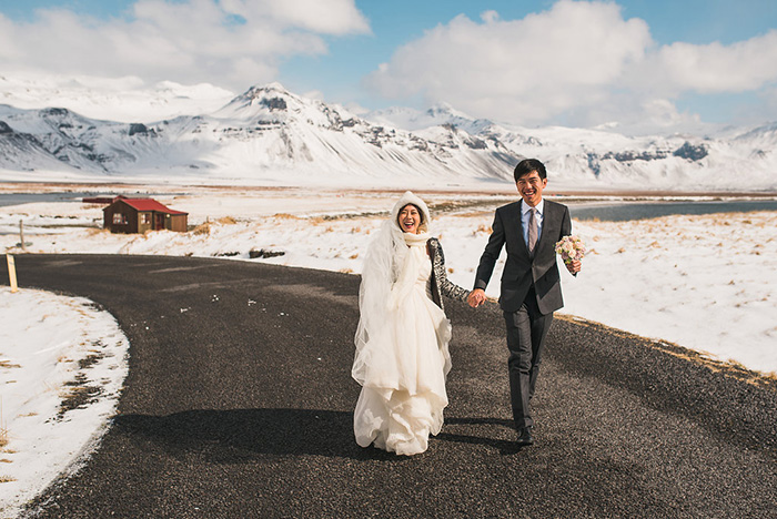 bride and groom walking down iceland road