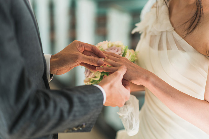 groom putting ring on bride's finger