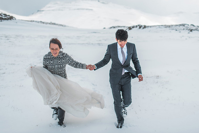 bride and groom walking through snow in Iceland