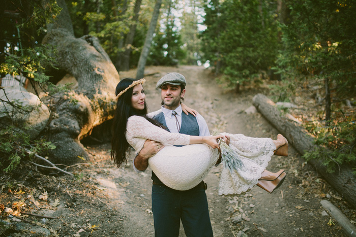 groom carrying bride down mountain