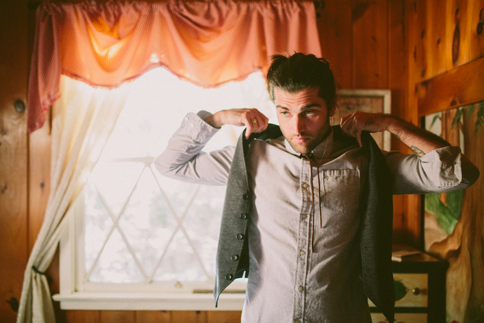 groom putting on vest