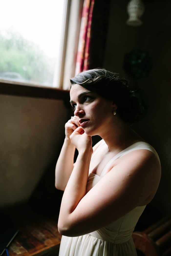 bride putting on earrings