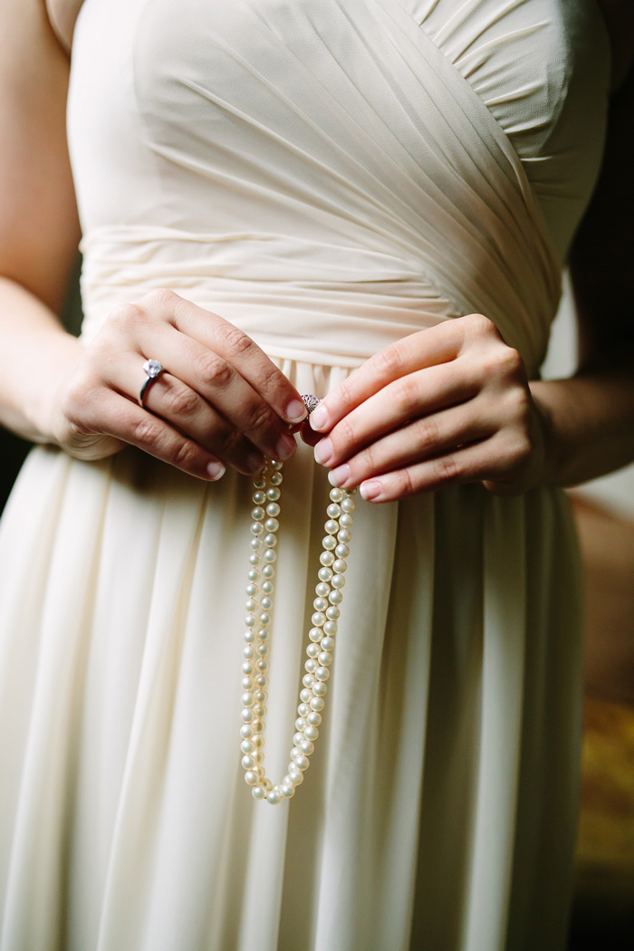 bride holding pearl necklace