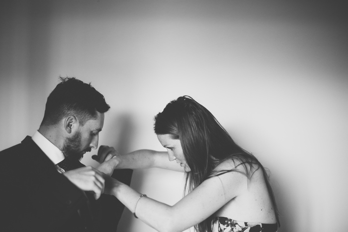 groom having boutonniere pinned on