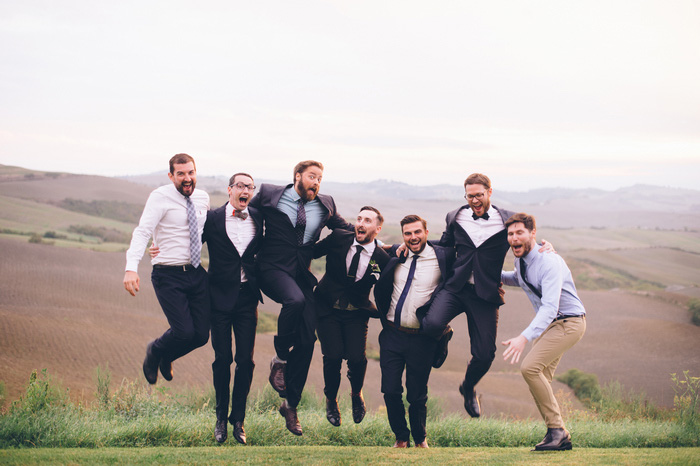 groom jumping with guests