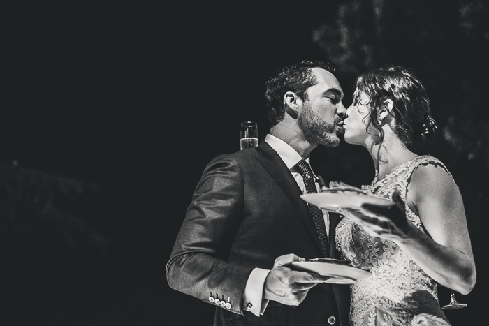 bride and groom kissing after cutting cake