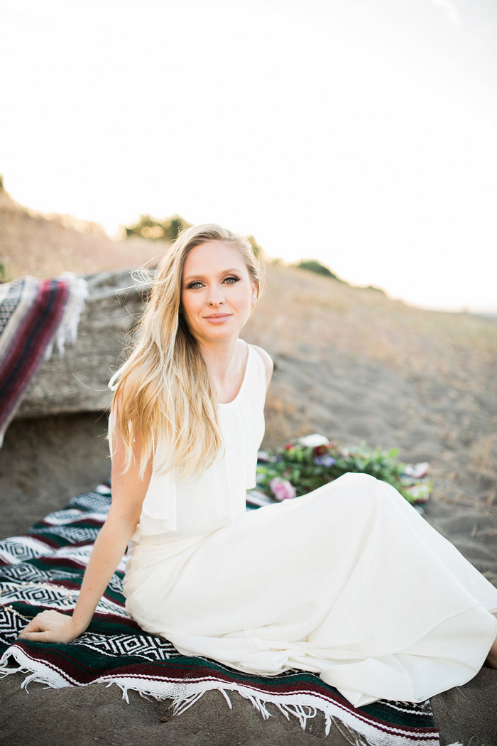 bride sitting on beach blanket