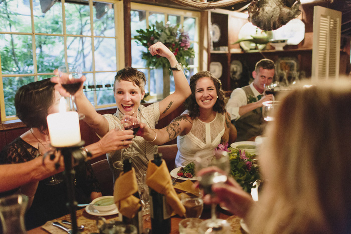 brides toasting with guests at reception dinner