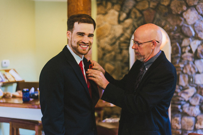 groom having his boutonniere pinned on