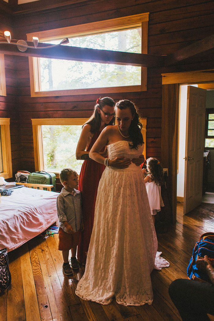 bride getting zipped into her dress