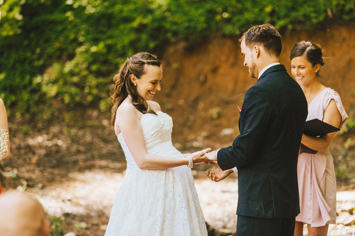 groom putting ring on bride's finger