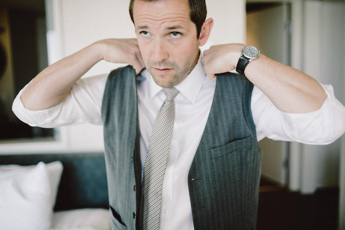 groom putting on vest