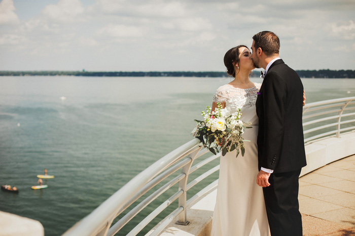 bride and groom kissing by the waterfront