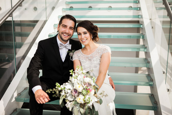 bride and groom sitting on glass steps