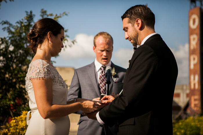 groom putting ring on bride's finger