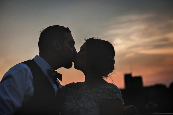 bride and groom kissing at dusk