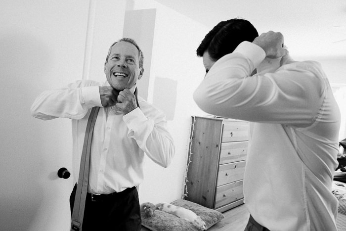 groom putting on his tie