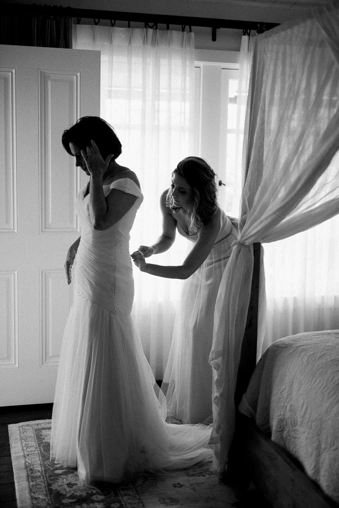 bride getting her dress buttoned