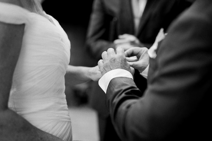 groom putting ring on bride's finger