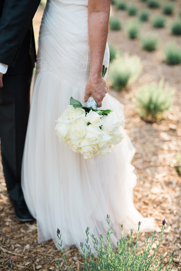 bride holding white wedding bouquet by her side