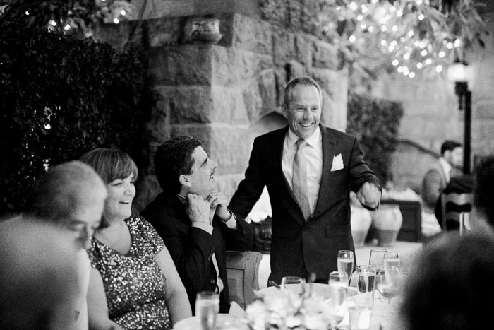 groom talking to guests at dinner